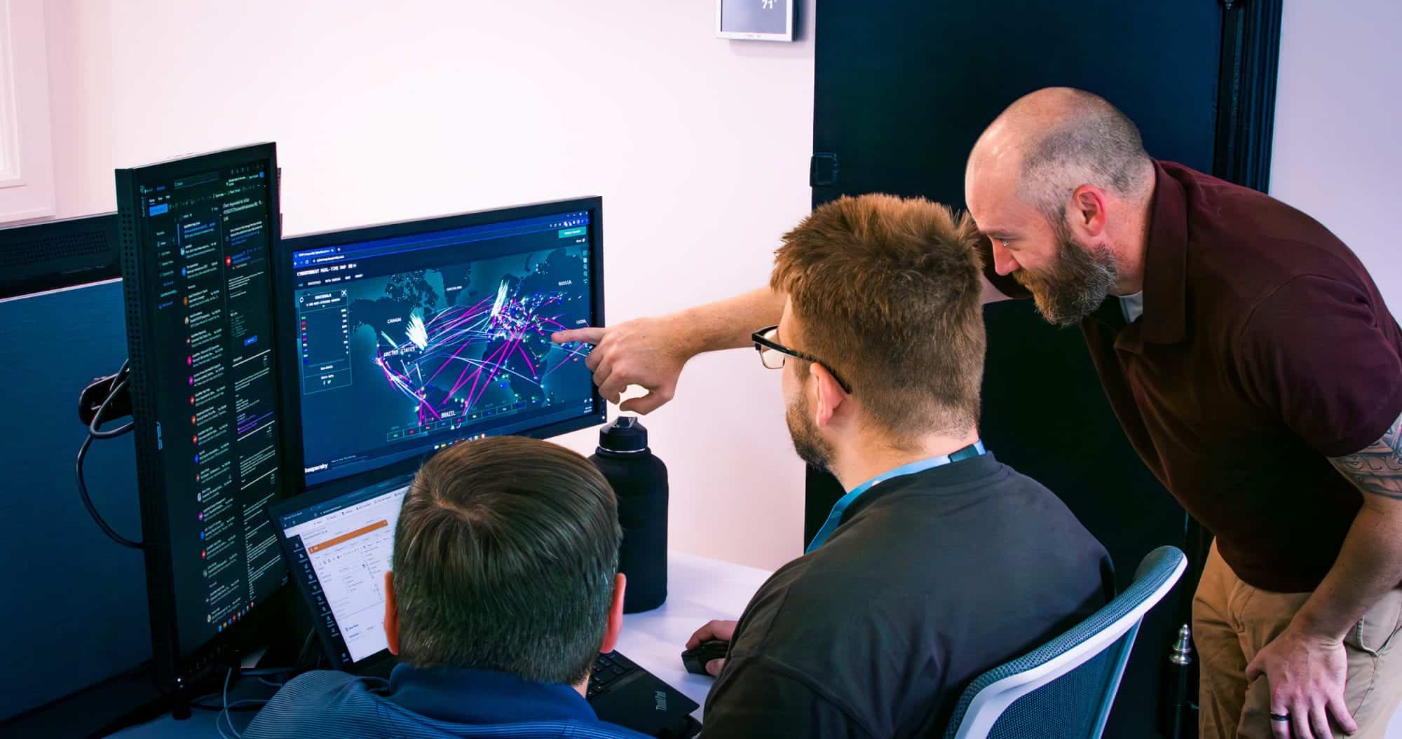 Cybersecurity analysts looking at cyber attacks on a computer