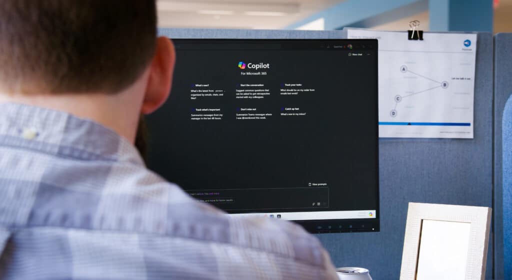 Over-the-shoulder look at an office worker's Copilot usage on a desktop computer.