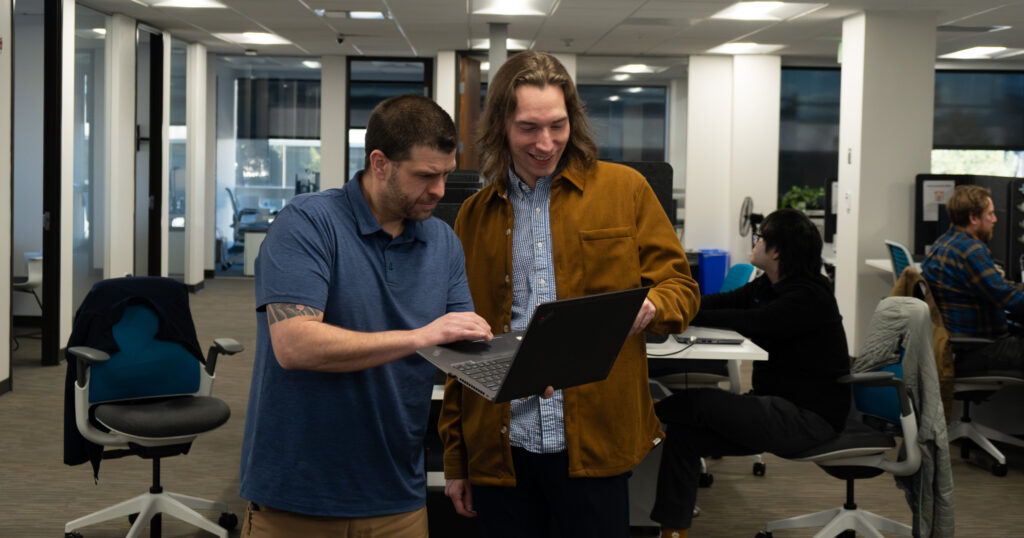 Two men looking at a computer.