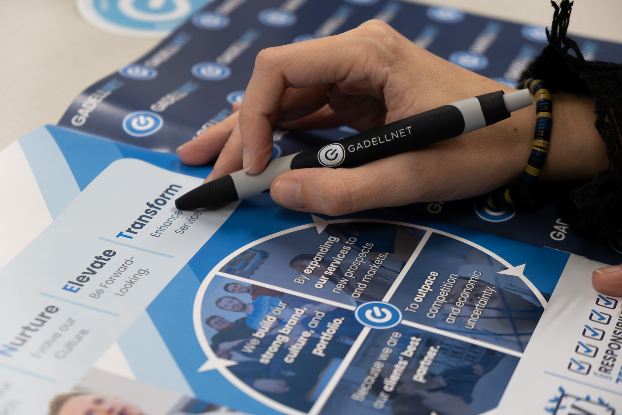 A hand with a GadellNet pen, pointing at the word "transform".