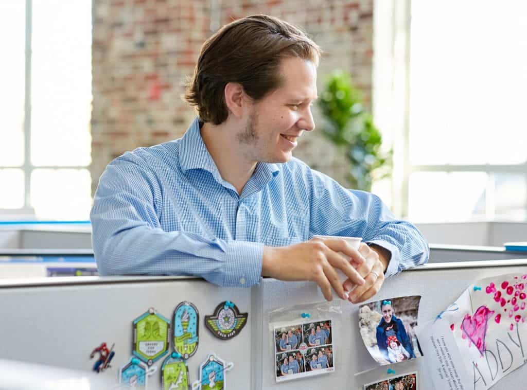 Employee smiling over cubicle