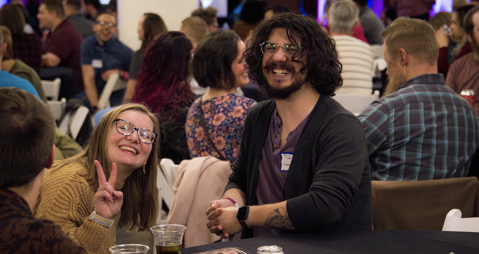 Two happy employees posing at company holiday party.